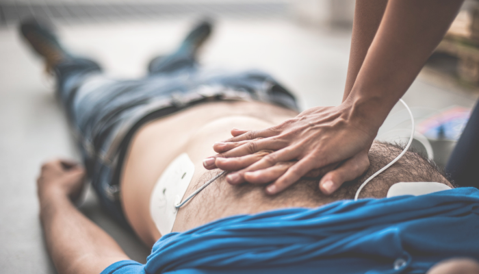 Male body on floor having chest compressions due to cardiac arrest