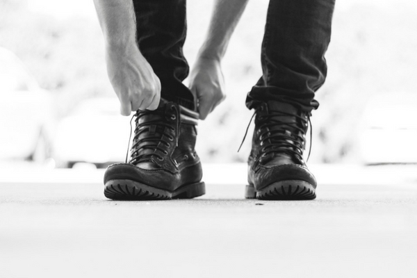 Male putting on safety work boots