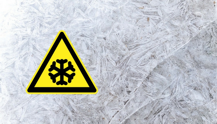 Yellow and black snow hazard symbol on ice background