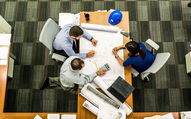 Two males and one female sitting at desk planning site opening