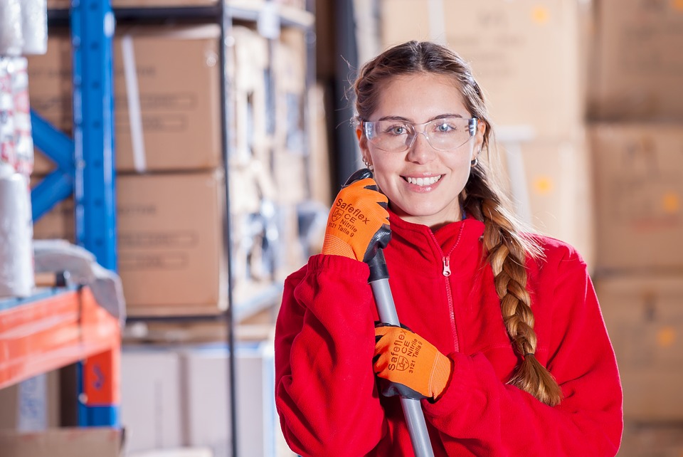 Lady at work wearing protective glasses, work gloves and red fleece