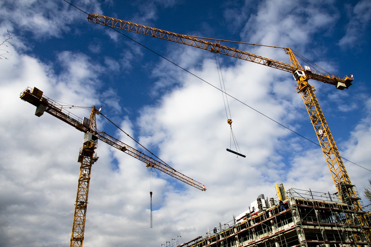 Two cranes moving material on a construction site